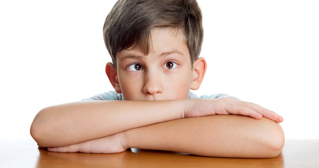 portrait image of a young boy with a squinting eye