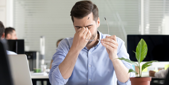 Man rubbing his eye due to dry eye